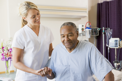 nurse helping senior man to walk